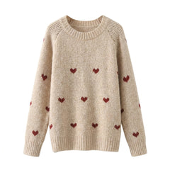 Beige sweater with red heart patterns on a white background