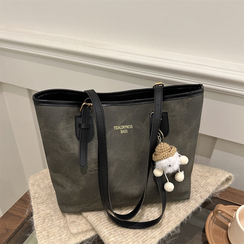 Gray tote bag with a black handle on a wooden surface
