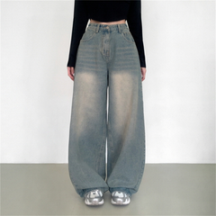 Person wearing high-waisted blue jeans and a black top on a plain background