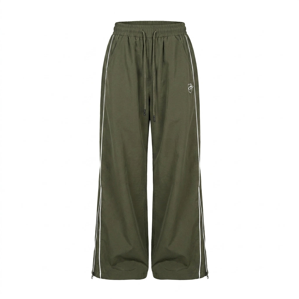 Green track pants with white stripes on a white background