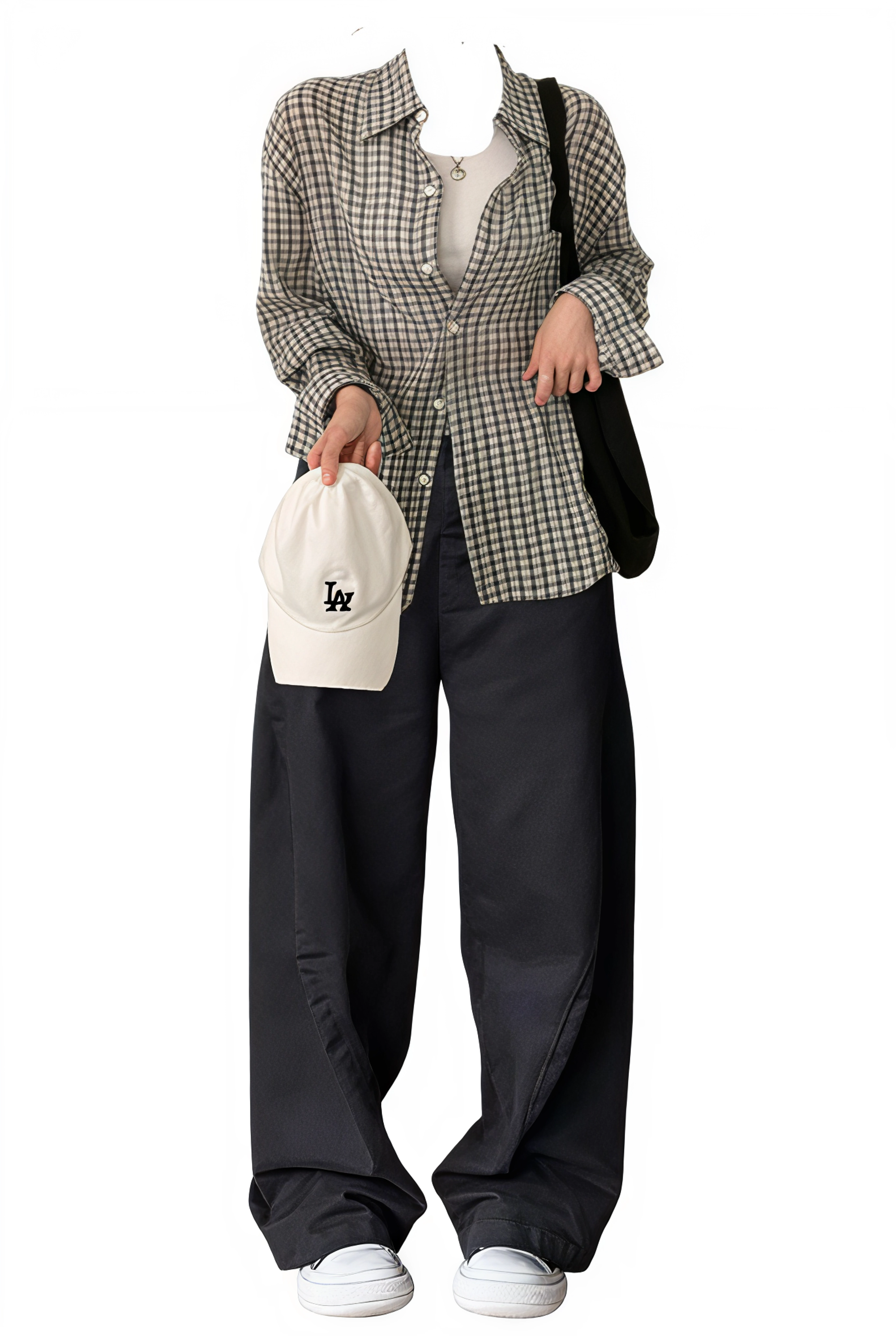 Person wearing a checkered shirt and black pants, holding a white bag with a logo.