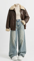 A brown leather aviator-style jacket with a beige shearling collar and cuffs, styled over a cream ribbed turtleneck and light-wash wide-leg denim jeans on a white mannequin against a white studio background.