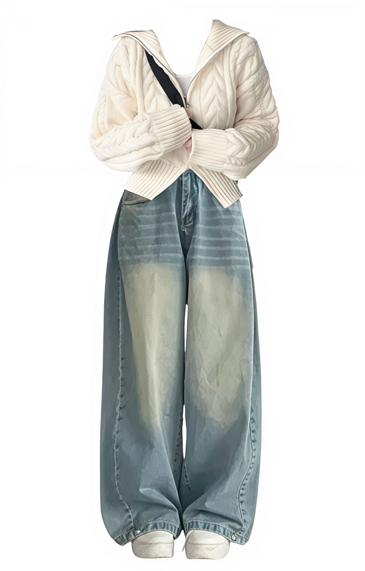 White cardigan over a black top with light blue jeans on a white background