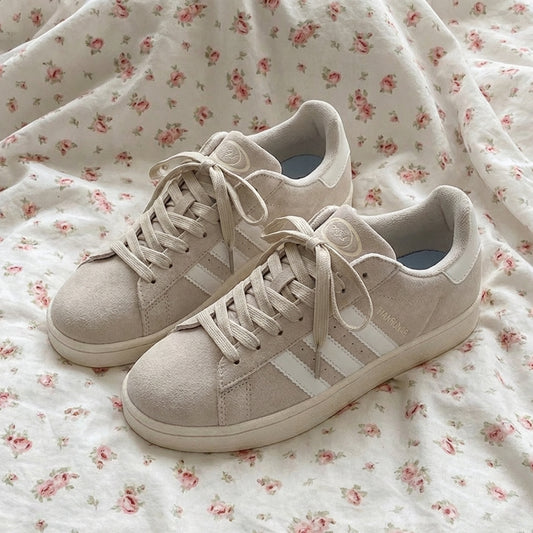 Beige sneakers on a floral fabric background
