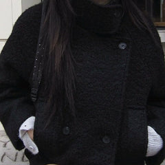 Loose quilted jacket with fluffy trim in black, seated