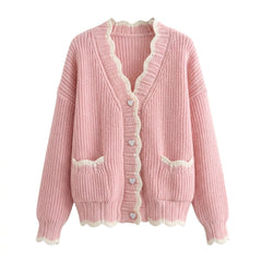 Pink knitted cardigan with lace details on a white background
