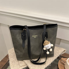 Gray tote bag with a black handle on a wooden surface