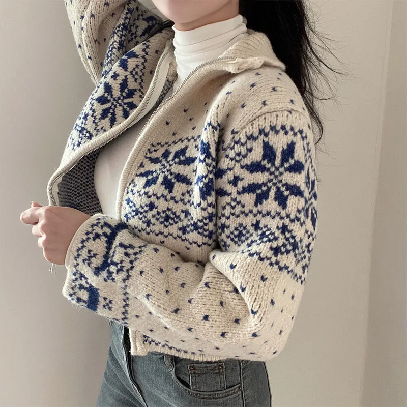 Person wearing a patterned sweater with a neutral background