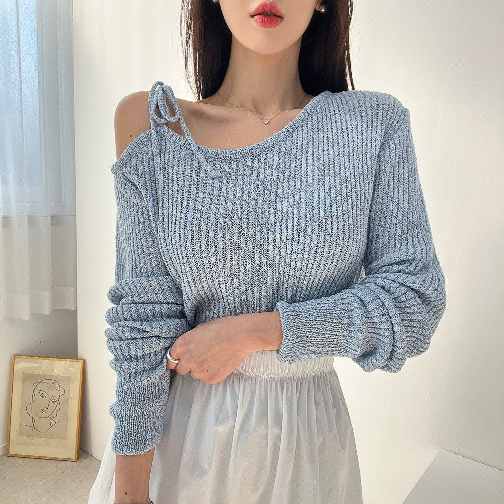 Woman wearing a light blue ribbed sweater with a plain background