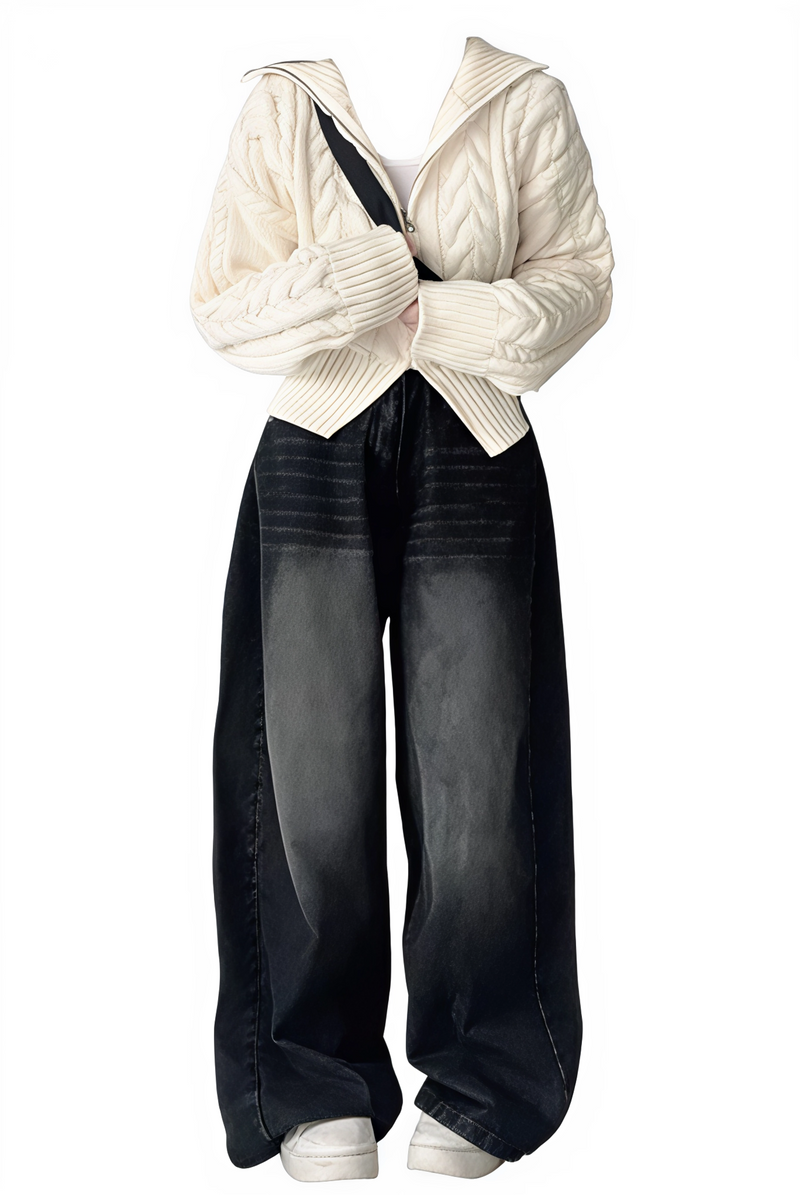 White cable knit sweater and dark jeans on a white background