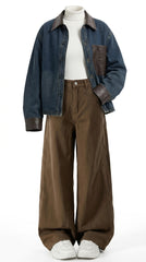 A mannequin styled with a dark blue denim jacket featuring brown leather-look trim, a white ribbed turtleneck, wide-leg brown pants, and white sneakers, set against a plain white background.