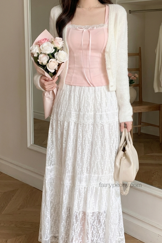 Person wearing a pink top and white lace skirt holding flowers and a handbag.