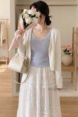 Woman holding flowers and a handbag in a room with wooden flooring and furniture.