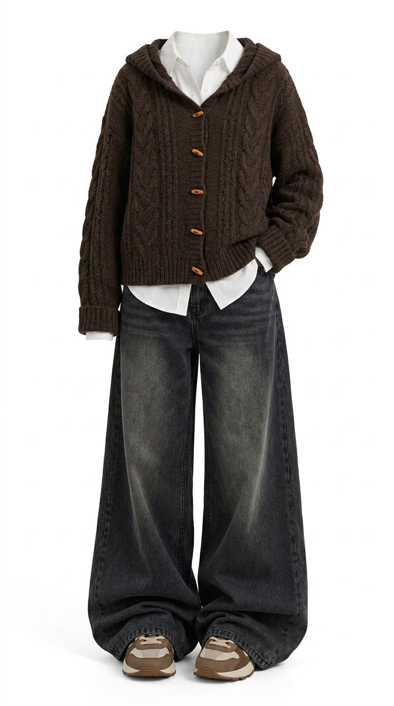 A child's outfit displayed on a mannequin against a white background, featuring a dark brown cable-knit cropped hoodie cardigan with orange buttons over a white collared shirt, wide-leg faded black jeans, and brown sneakers.