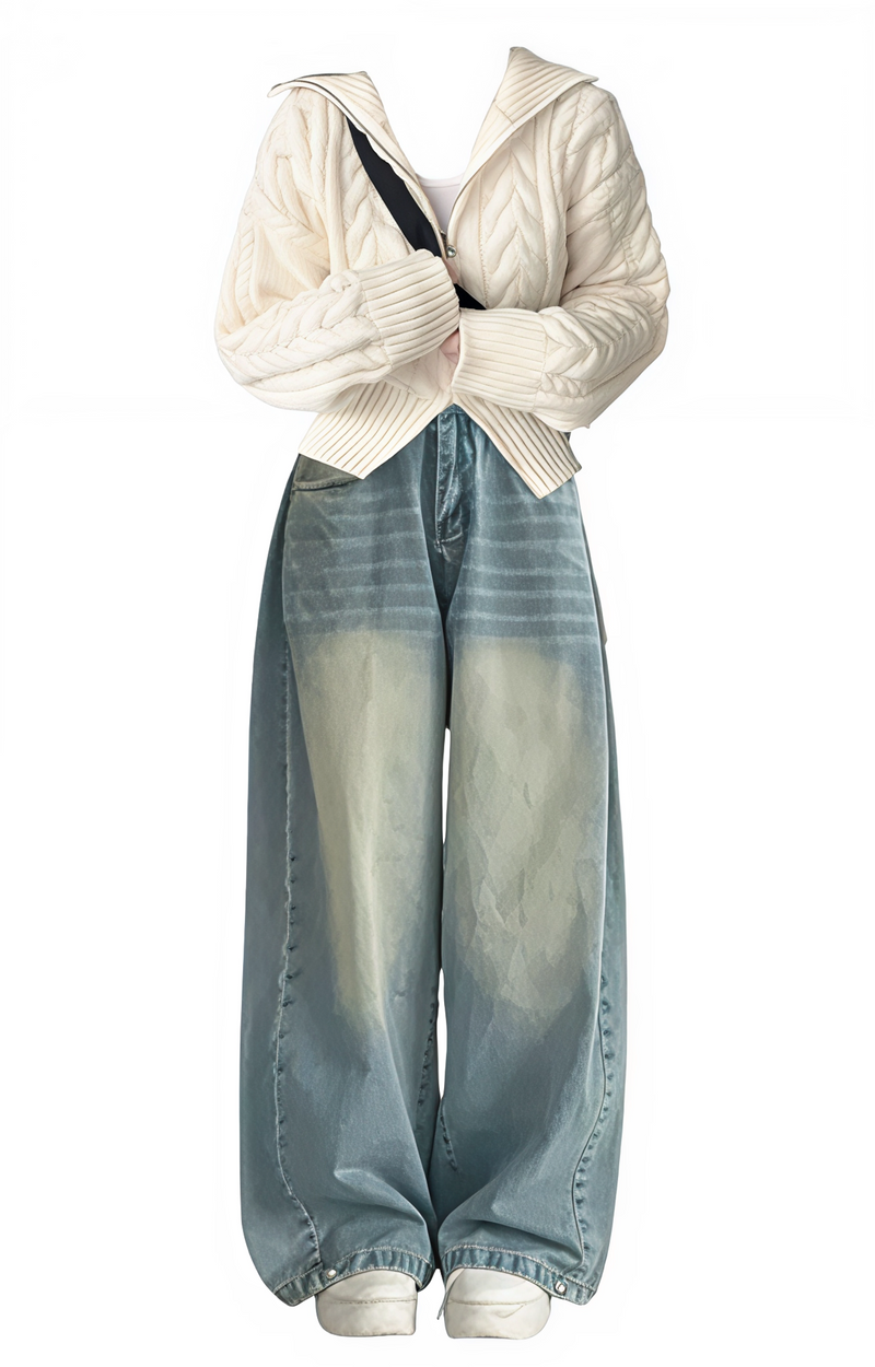 White cardigan over a black top with light blue jeans on a white background