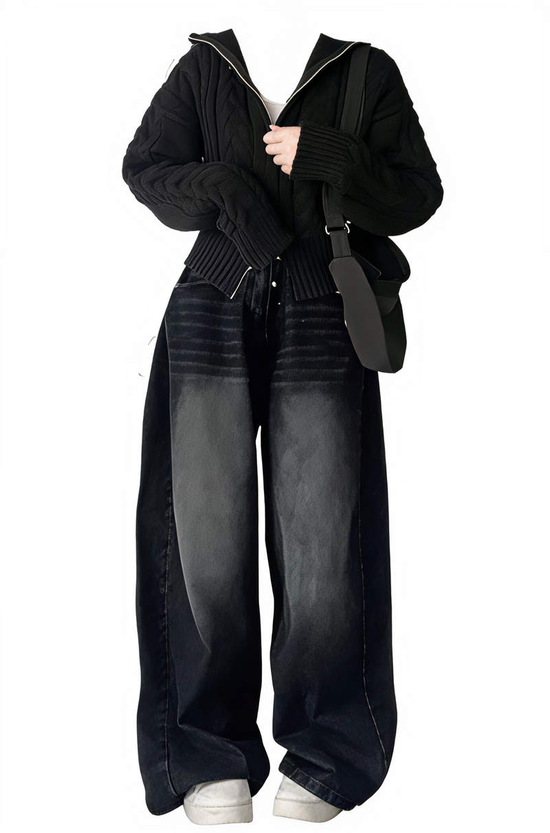 Person wearing a black outfit with wide-leg jeans and a black jacket on a white background