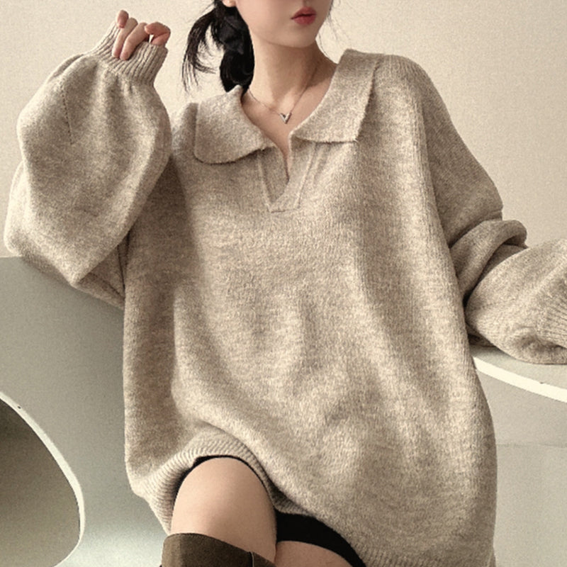 Person wearing a beige sweater with a collar on a neutral background