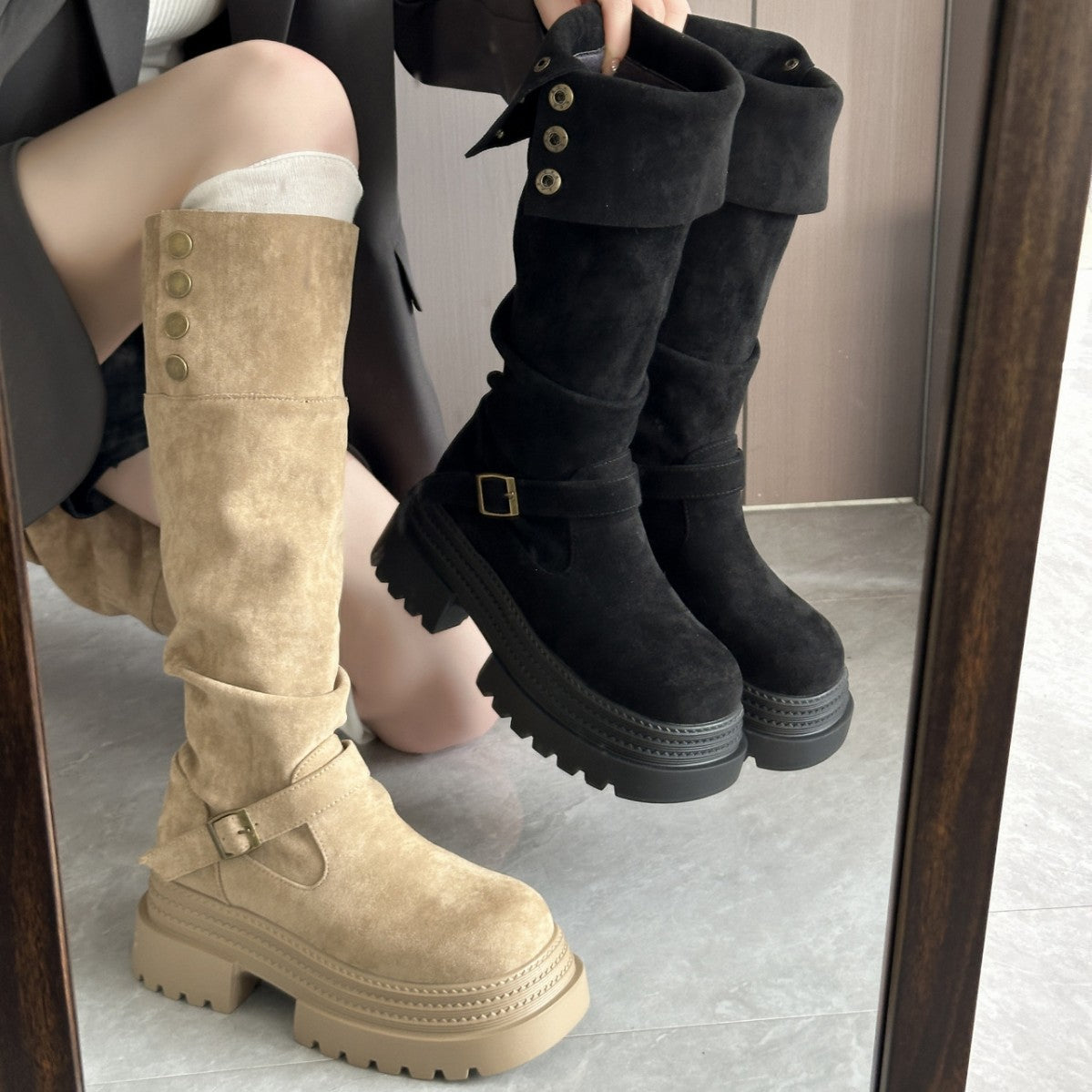 Beige and black knee-high boots being worn, with a mirror reflection.