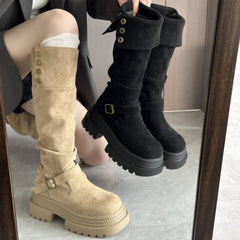 Beige and black knee-high boots being worn, with a mirror reflection.