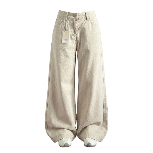 A pair of wide-leg, balloon-style pants in a light beige or cream color, shown on a plain white background. The pants have a relaxed, voluminous fit and are styled with white sneakers at the bottom.