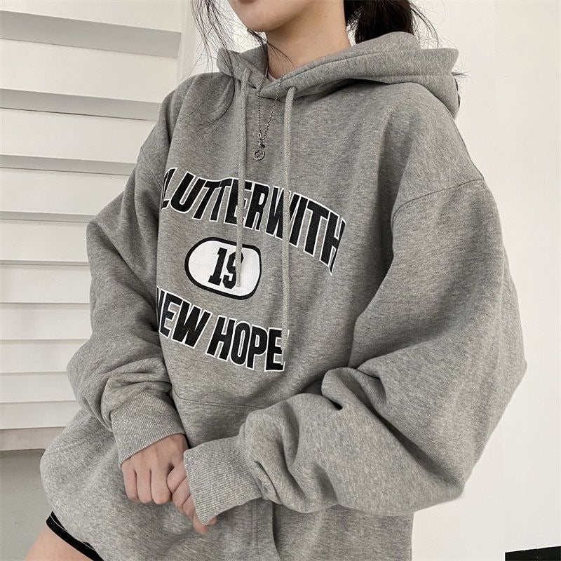 Person wearing a gray hoodie with text on a white background