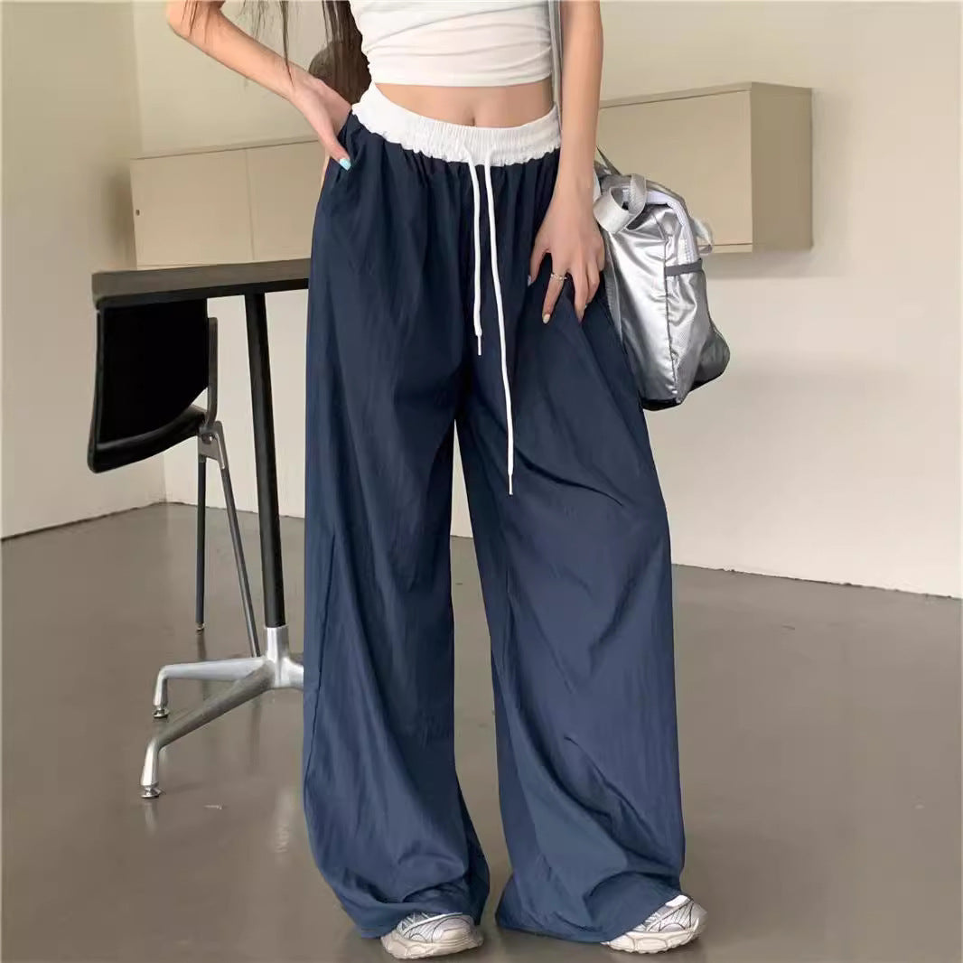 Person wearing navy wide-leg pants with a white top in an indoor setting.