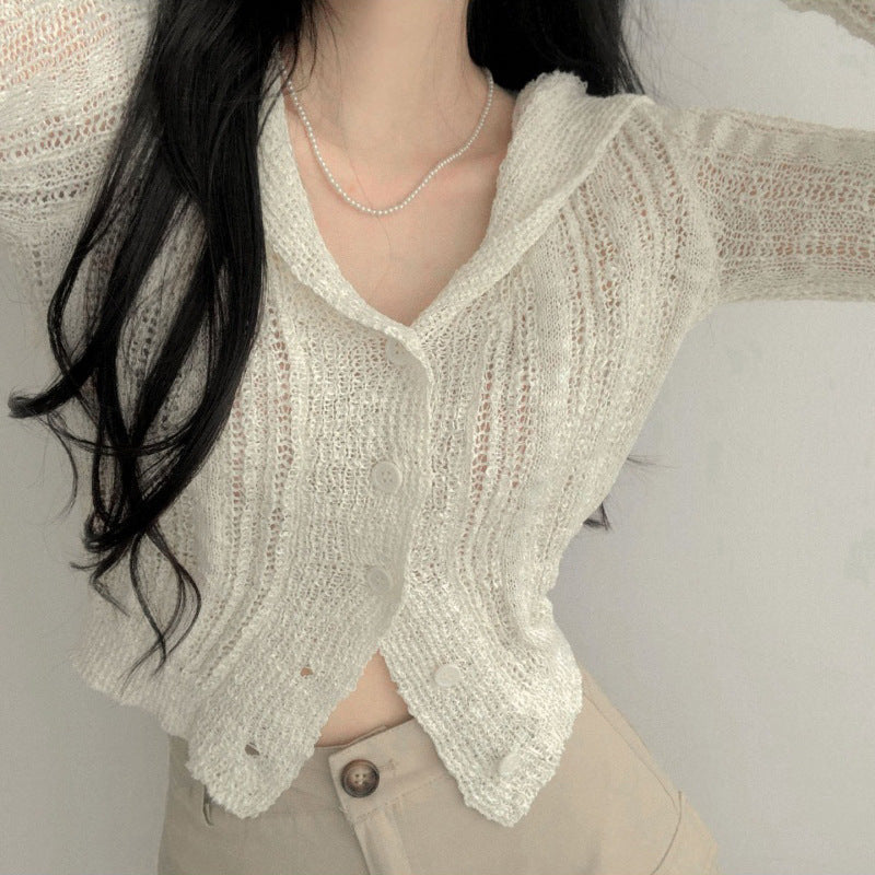 Person wearing a light beige knitted cardigan against a neutral background