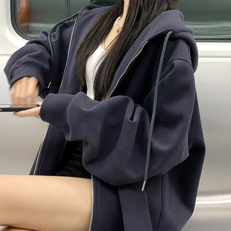 Person wearing a dark blue hoodie sitting inside a vehicle.