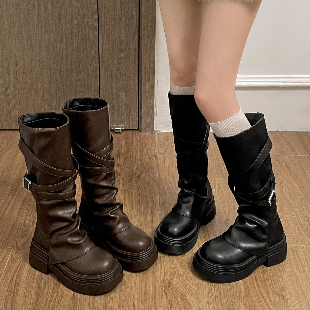 Brown and black knee-high boots on a wooden floor.