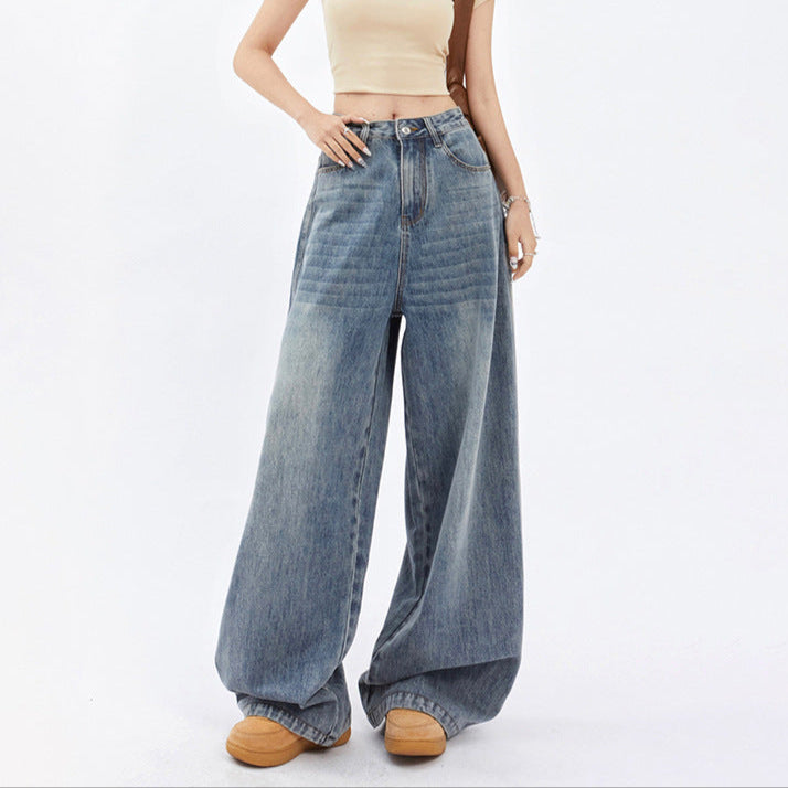 Person wearing high-waisted blue jeans and a beige top on a white background