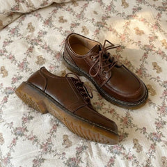 Pair of brown leather shoes on a floral-patterned fabric background