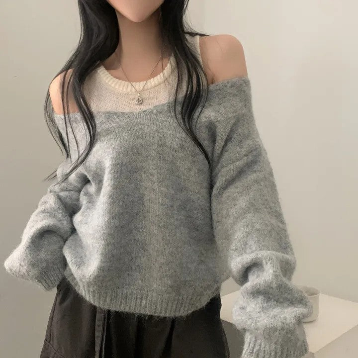 Person wearing a gray off-shoulder sweater with a plain background