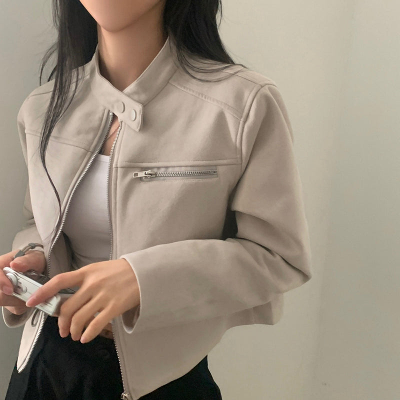 Person wearing a beige jacket with a neutral background