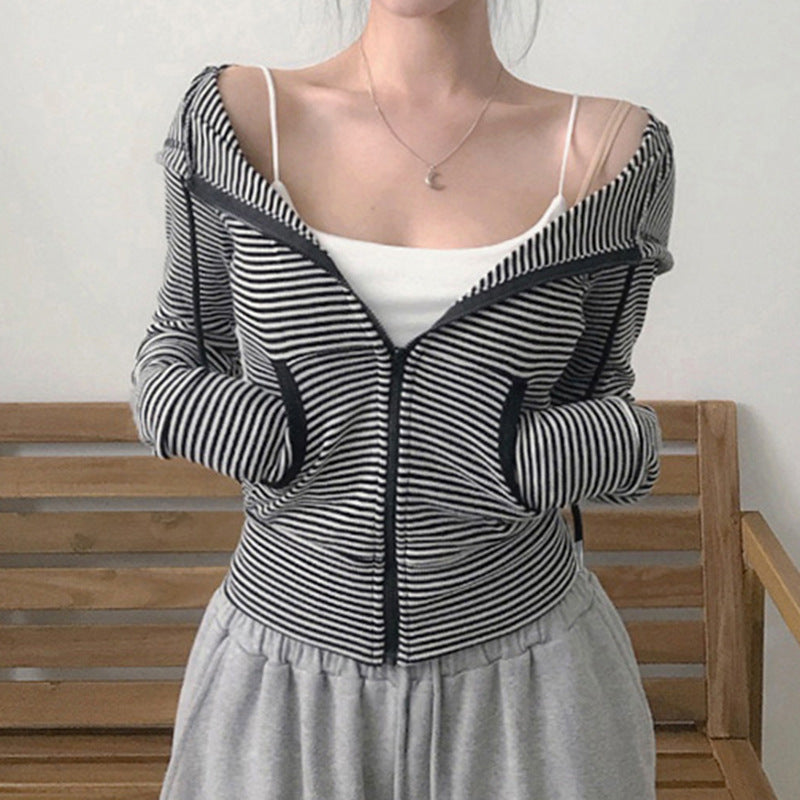 Person wearing a black and white striped hoodie with a plain background